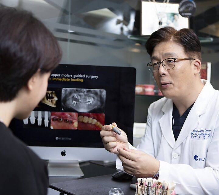 강남 당뇨 임플란트 상담 – 의료진이 임플란트 픽스처를 들고 환자에게 설명하는 모습